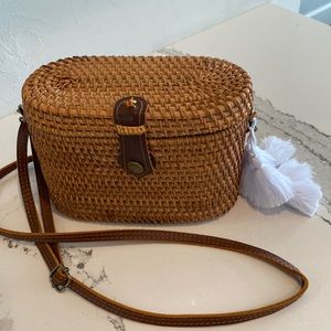 Light brown wicker/rattan purse with blue and white check fabric on the inside.